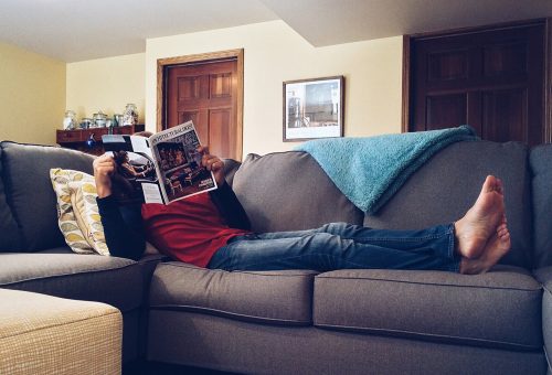 Person on sofa reading magazine