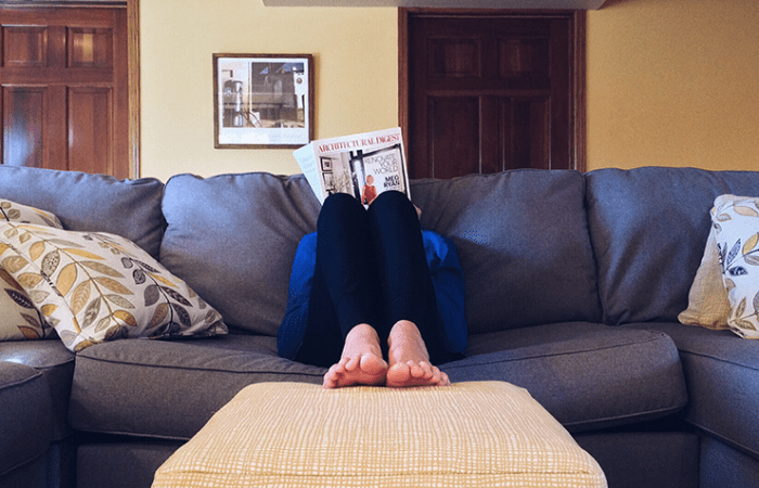 Person readying magazine on sofa