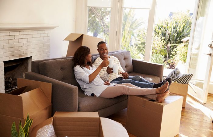 Two people sharing hot drink on sofa